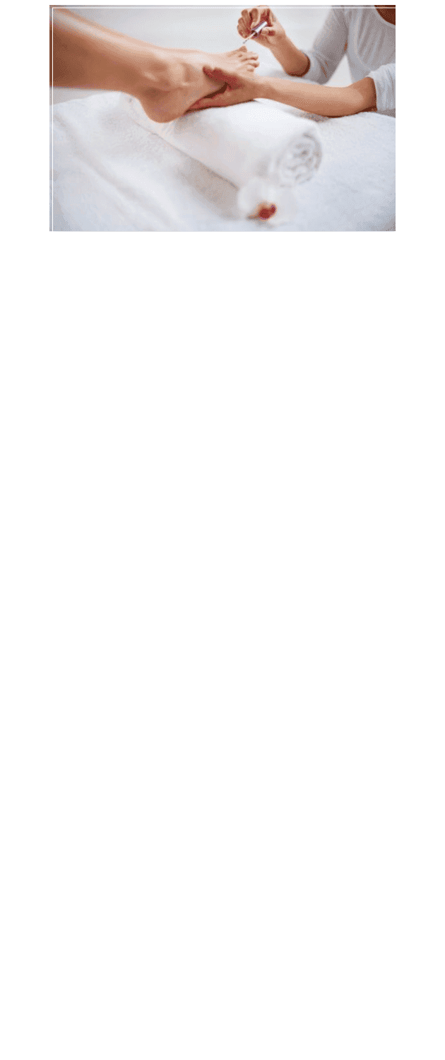 Manicure in progress: person getting nail polish applied at a spa on a rolled white towel.