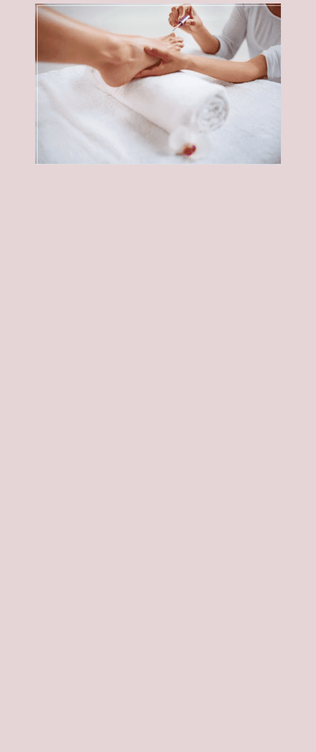 Person receiving a professional manicure, nails being painted on a rolled white towel.