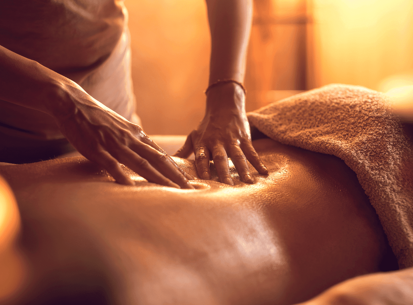 Person receiving a relaxing massage with warm lighting.