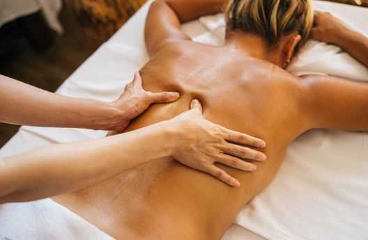 Person receiving a back massage therapy session on a table.